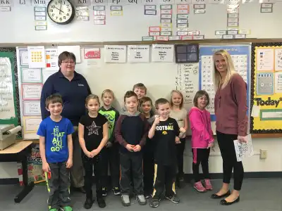 Image of two volunteers with group of students